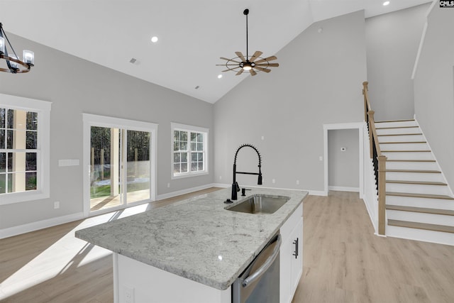 kitchen featuring white cabinetry, dishwasher, sink, light hardwood / wood-style flooring, and high vaulted ceiling