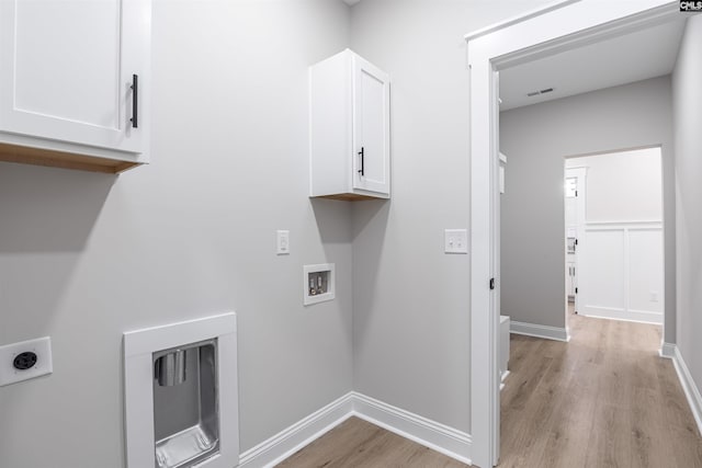 laundry room featuring electric dryer hookup, hookup for a washing machine, cabinets, and light wood-type flooring