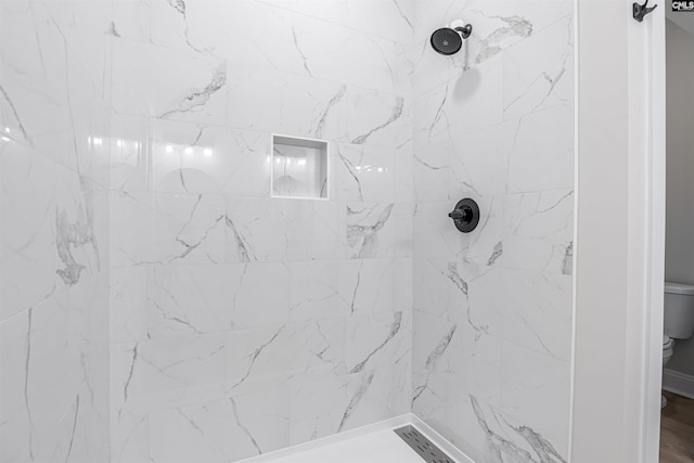 bathroom with toilet and a tile shower
