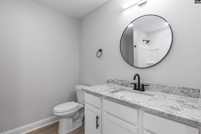 bathroom featuring hardwood / wood-style floors, vanity, toilet, and walk in shower