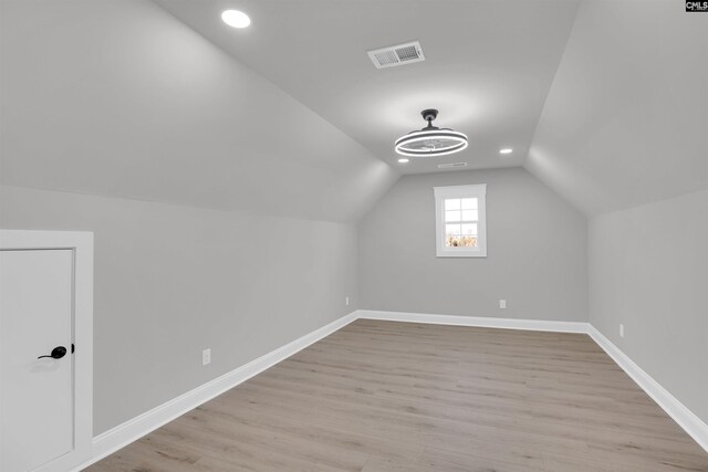 bonus room with light hardwood / wood-style floors and vaulted ceiling