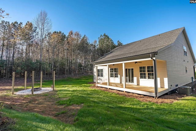 back of property featuring ceiling fan, cooling unit, and a yard