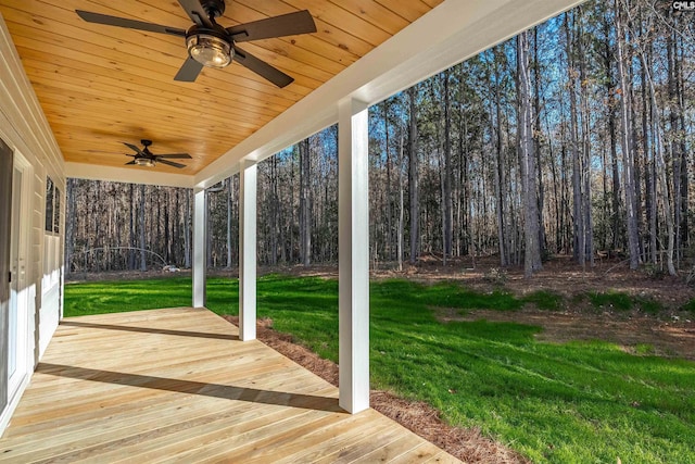 wooden deck featuring ceiling fan and a yard