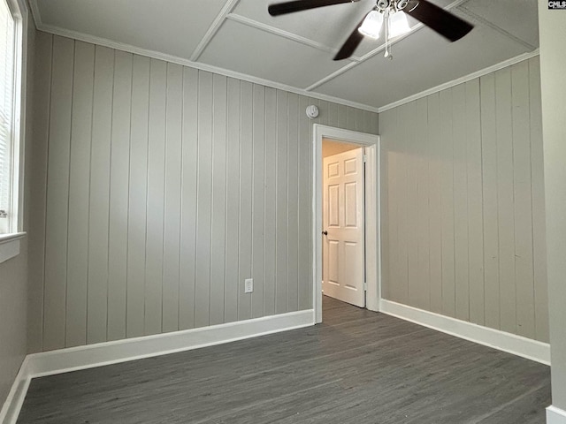 spare room featuring dark hardwood / wood-style flooring, crown molding, ceiling fan, and wooden walls