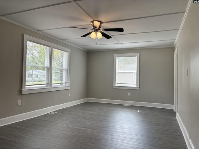 spare room featuring plenty of natural light, dark hardwood / wood-style floors, crown molding, and ceiling fan