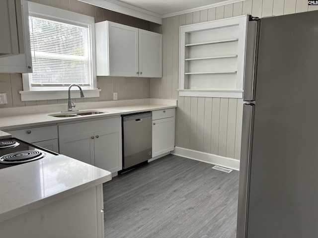 kitchen featuring crown molding, sink, light hardwood / wood-style flooring, white cabinetry, and stainless steel appliances