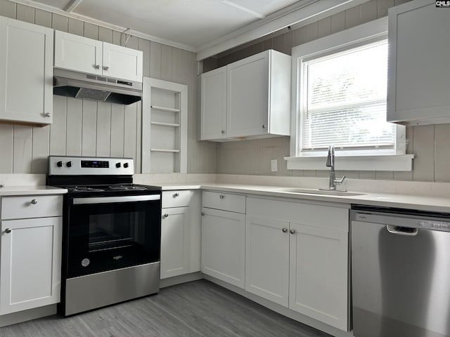 kitchen featuring stainless steel appliances, crown molding, sink, light hardwood / wood-style flooring, and white cabinets