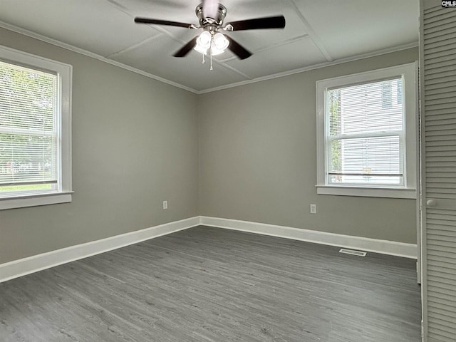 empty room featuring dark hardwood / wood-style flooring, crown molding, and a wealth of natural light