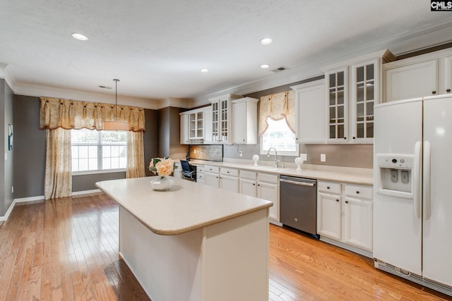 kitchen with dishwasher, glass insert cabinets, light countertops, white fridge with ice dispenser, and white cabinetry