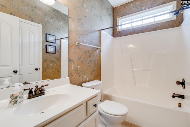 bathroom featuring toilet, vanity, washtub / shower combination, and wallpapered walls