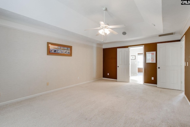 unfurnished bedroom featuring light carpet, visible vents, a tray ceiling, and ornamental molding