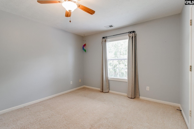 unfurnished room with light carpet, baseboards, visible vents, and a ceiling fan