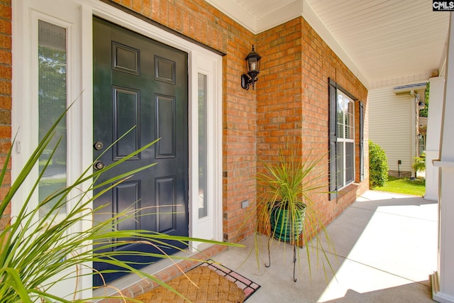 doorway to property with brick siding