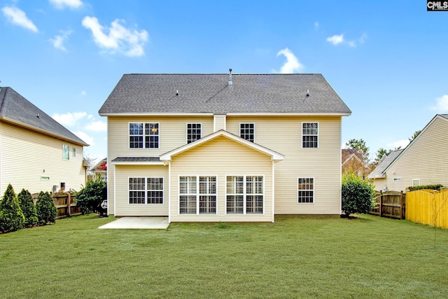 back of property featuring a patio, a shingled roof, a lawn, and a fenced backyard