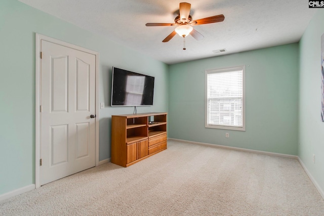 living room with light carpet, ceiling fan, visible vents, and baseboards