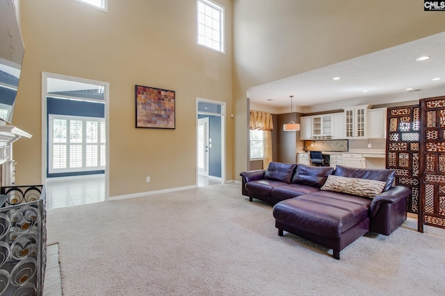 living room featuring plenty of natural light, a fireplace, baseboards, and light colored carpet