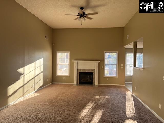 unfurnished living room featuring carpet and plenty of natural light