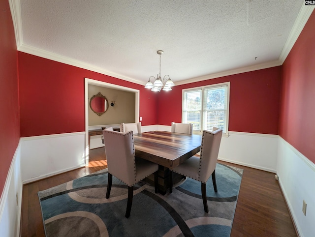 dining space featuring dark hardwood / wood-style floors, ornamental molding, and a textured ceiling