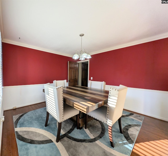 dining area with ornamental molding, dark hardwood / wood-style floors, and a notable chandelier