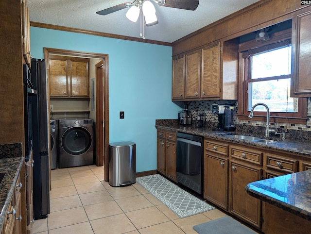 kitchen featuring dishwasher, sink, decorative backsplash, light tile patterned floors, and washer and dryer