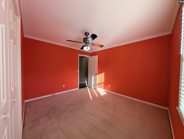 unfurnished bedroom with carpet, ceiling fan, and crown molding