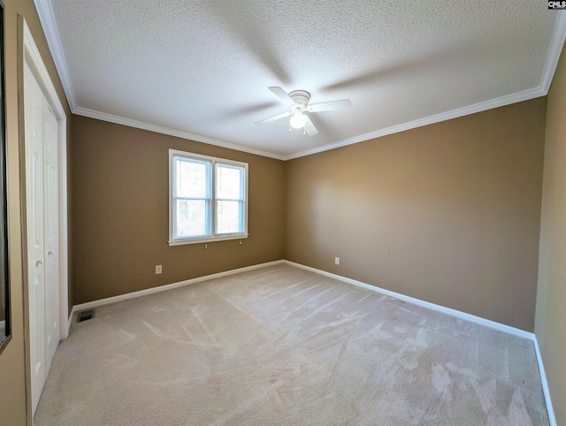 unfurnished bedroom with ceiling fan, light carpet, and a textured ceiling