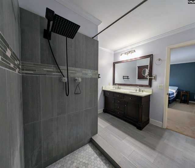 bathroom featuring a tile shower, vanity, and ornamental molding