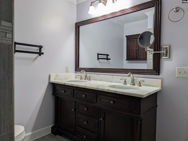 bathroom featuring vanity, toilet, and ornamental molding