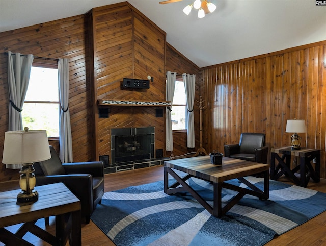 living room featuring wooden walls, wood-type flooring, and vaulted ceiling