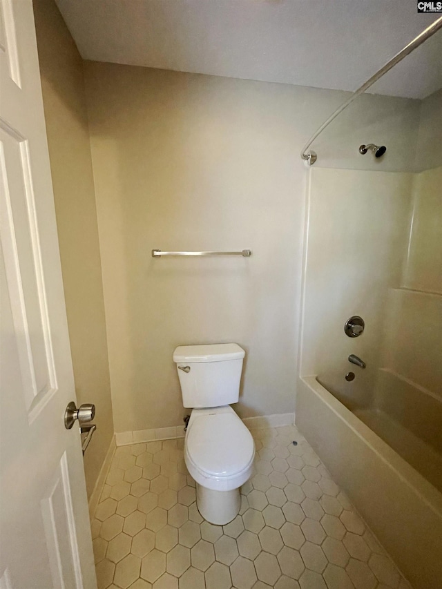 bathroom featuring tile patterned floors, washtub / shower combination, and toilet