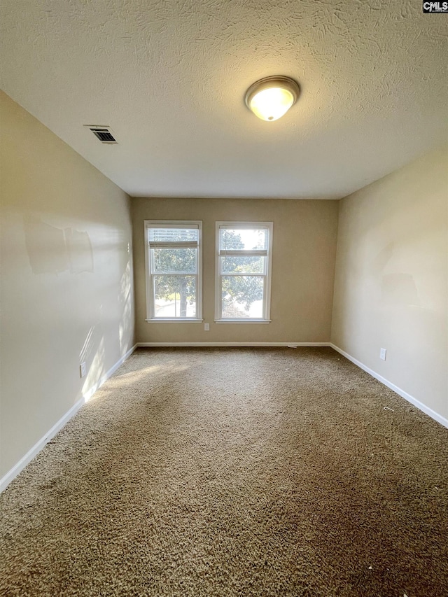 unfurnished room featuring carpet floors and a textured ceiling