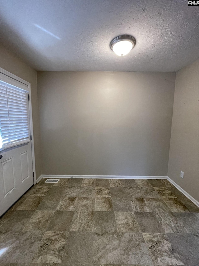 spare room with a textured ceiling