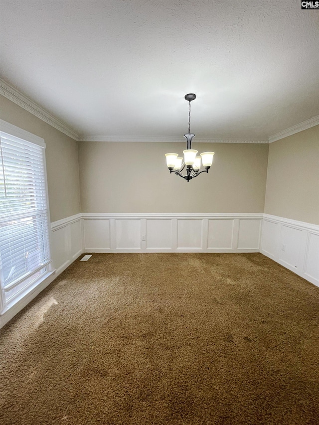 carpeted empty room featuring a notable chandelier and crown molding