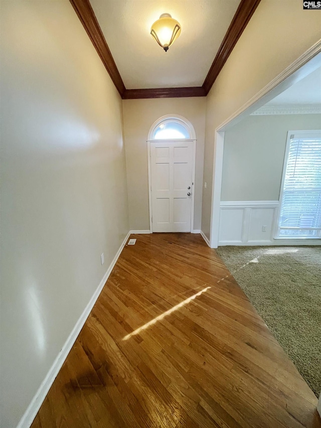 foyer entrance with hardwood / wood-style flooring and crown molding