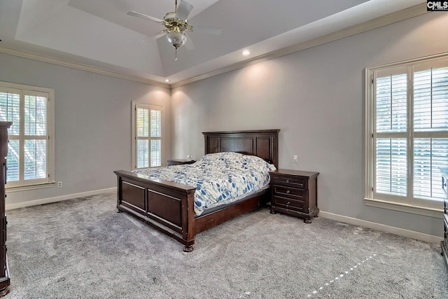 bedroom with carpet flooring, a raised ceiling, ceiling fan, and ornamental molding