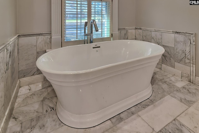 bathroom featuring a bathing tub and tile walls