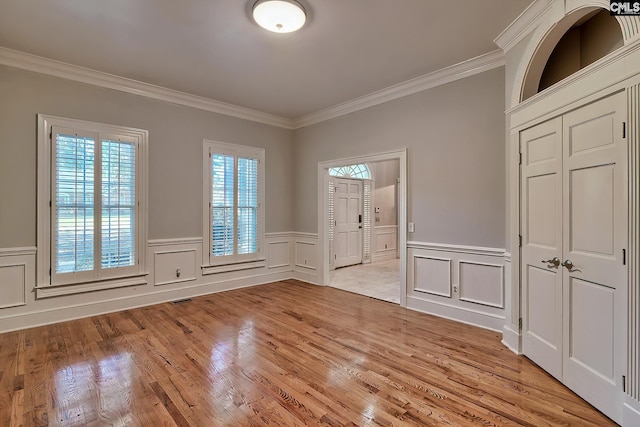 interior space with crown molding and light hardwood / wood-style flooring