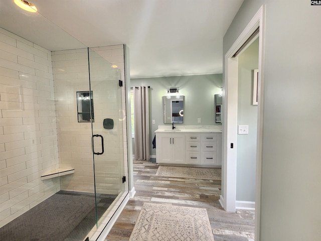 bathroom with hardwood / wood-style floors, vanity, and walk in shower