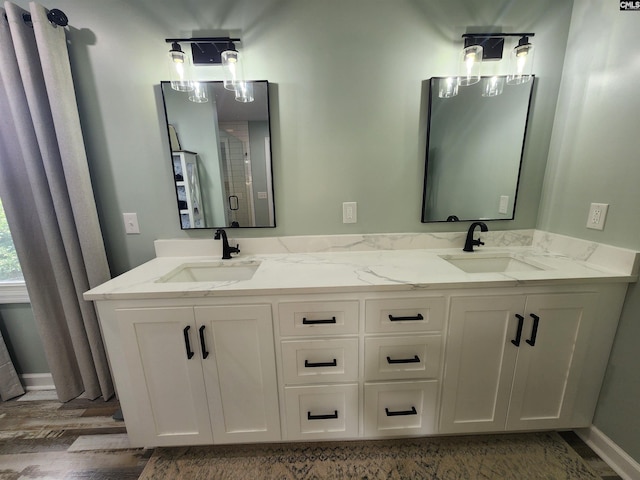 bathroom with hardwood / wood-style floors, vanity, and a shower with shower door