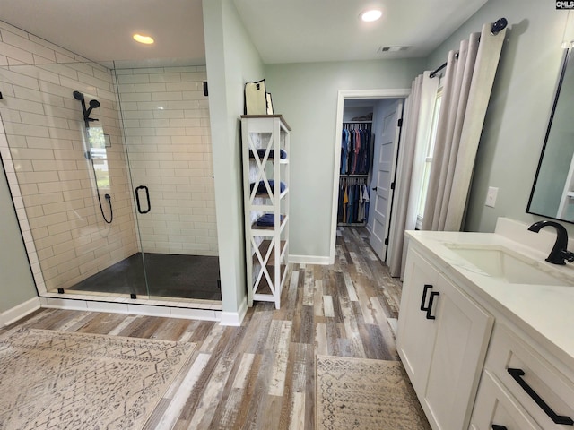 bathroom with vanity, wood-type flooring, and a shower with door