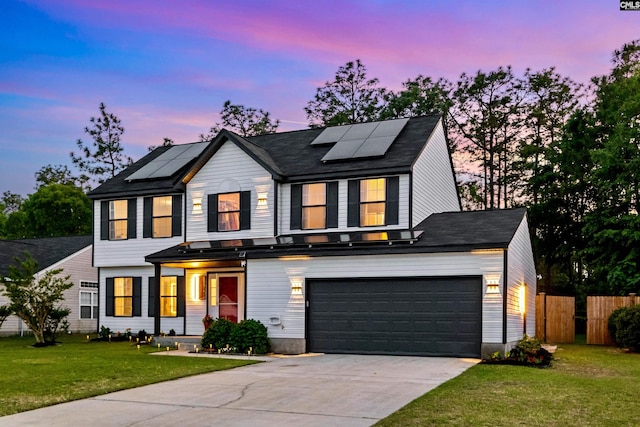 view of front of property featuring solar panels, a garage, and a lawn