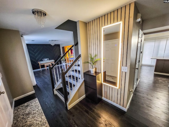 stairway with hardwood / wood-style flooring and a notable chandelier