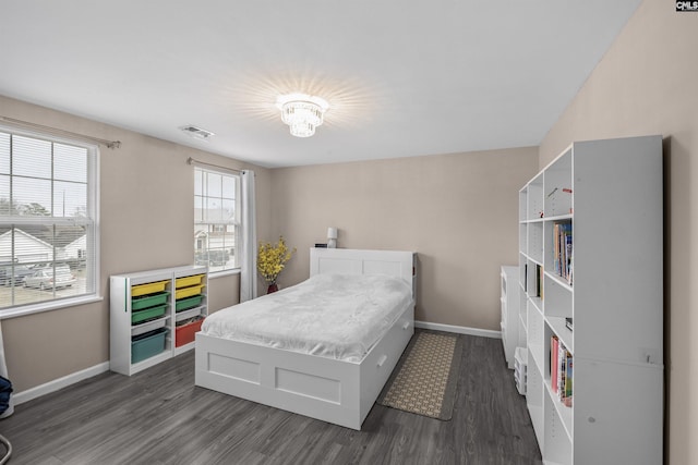 bedroom featuring a notable chandelier and dark hardwood / wood-style flooring