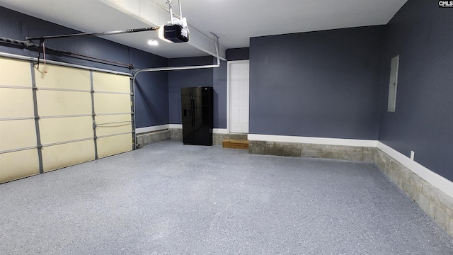 garage with black refrigerator with ice dispenser and a garage door opener