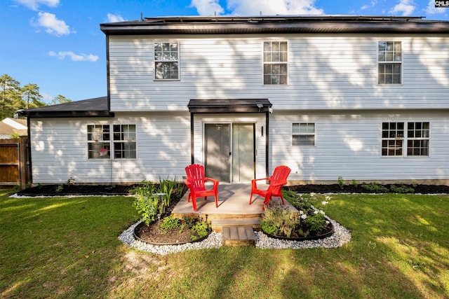 back of house with a lawn and a patio