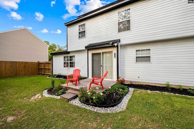 rear view of house featuring a yard and a deck