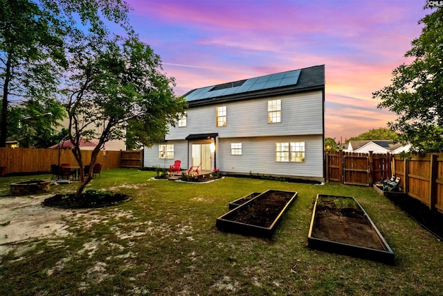 back house at dusk featuring a yard