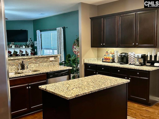 kitchen with stainless steel dishwasher, dark brown cabinets, sink, hardwood / wood-style floors, and a kitchen island