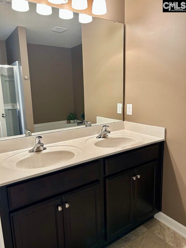 bathroom with tile patterned floors, vanity, and a shower with shower door