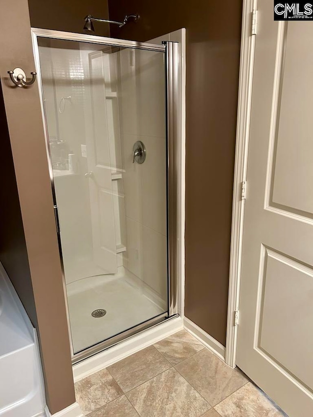 bathroom featuring tile patterned floors and a shower with shower door